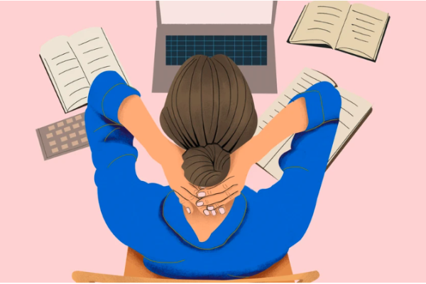 A woman works at her laptop and clasps both hands behind her head in a manner that indicates anxiety.