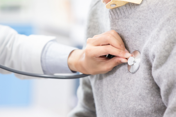 A doctor checking a patient's heartbeat