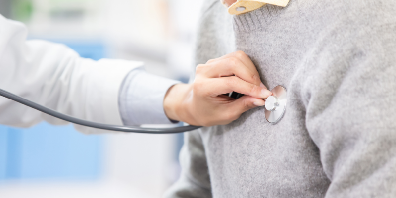 A doctor checking a patient's heartbeat