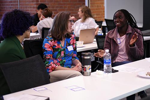 A student speaks excitedly about their work with fellow seminar attendees.