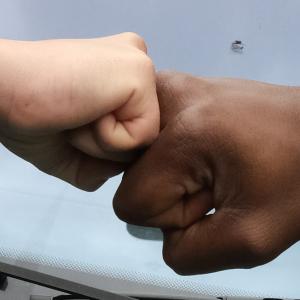 White and Black hand fist bumping